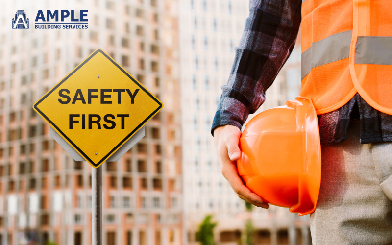 Construction worker holding a hard hat next to a "Safety First".