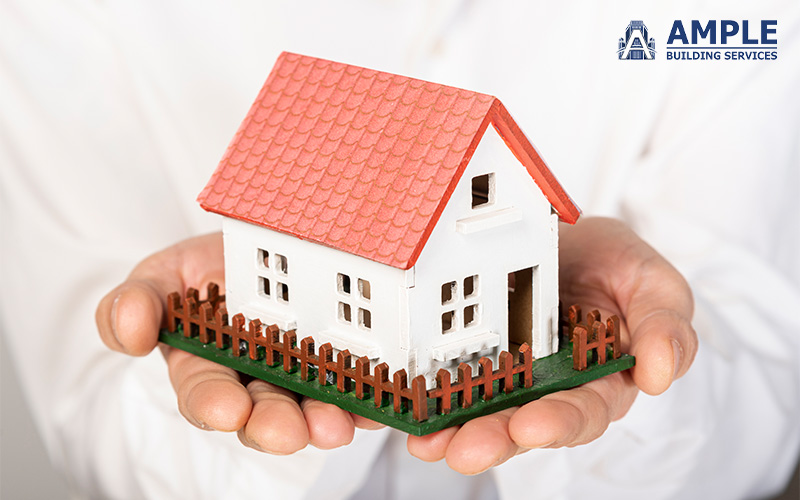 Hands holding a miniature house, representing property reinstatement.